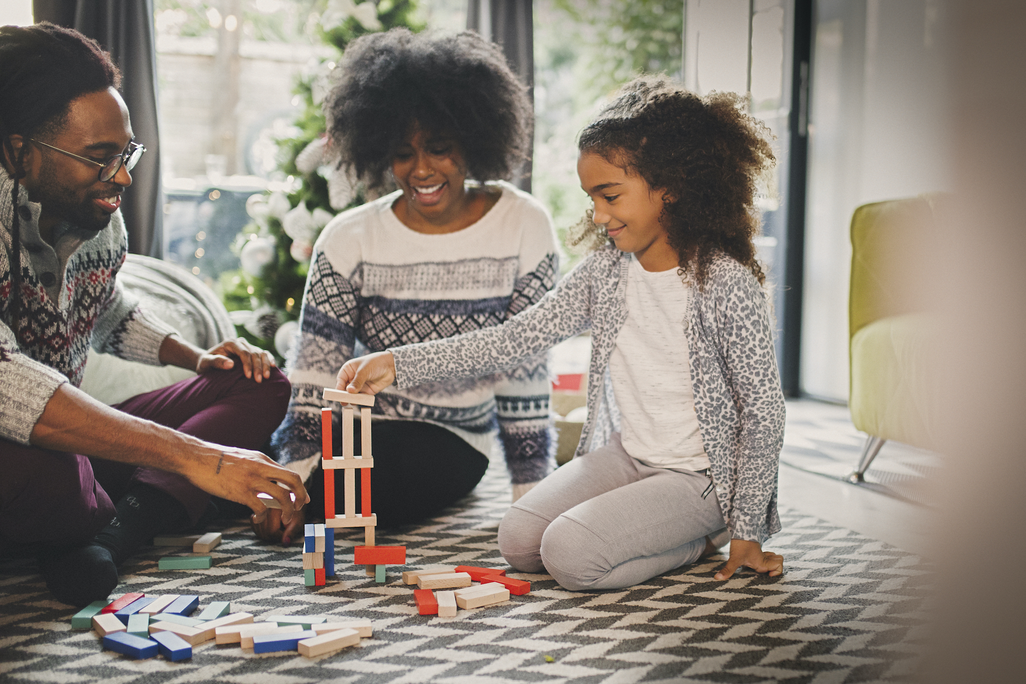 Black family plays with blocks in the living room
