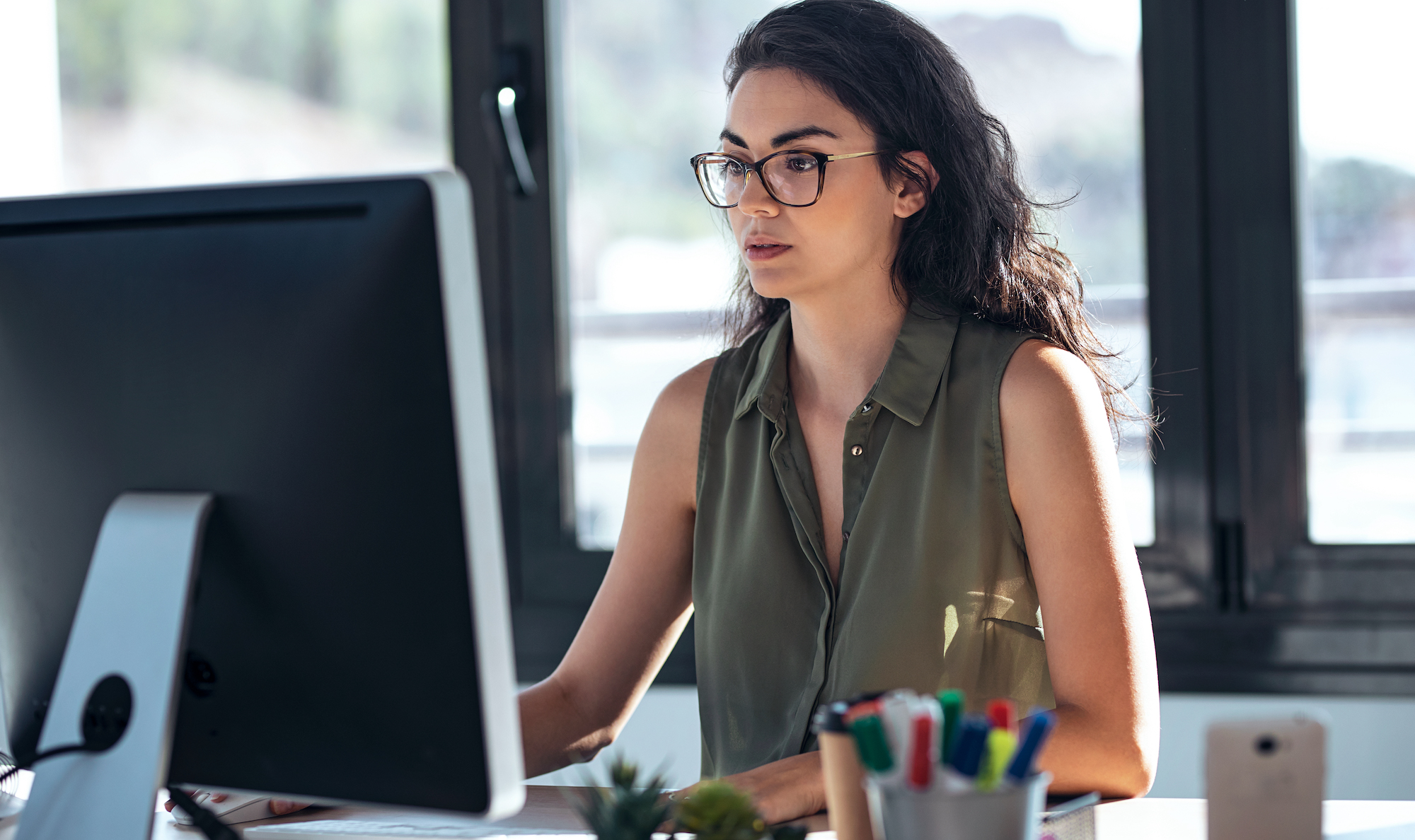 Woman working on computer seated at desk